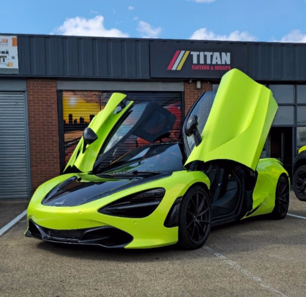 Bright green sports car with open scissor doors parked outside Titan Tinting & Wraps workshop